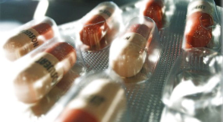 Hand holding a yellow gel capsule