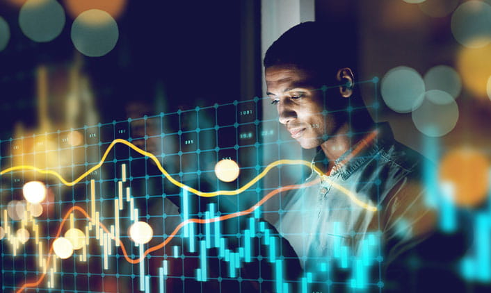 A person analyzes data displayed with colorful graphs and glowing lights.