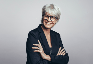 A person smiling with their arms crossed.