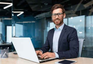 A person sitting at a desk using a laptop.