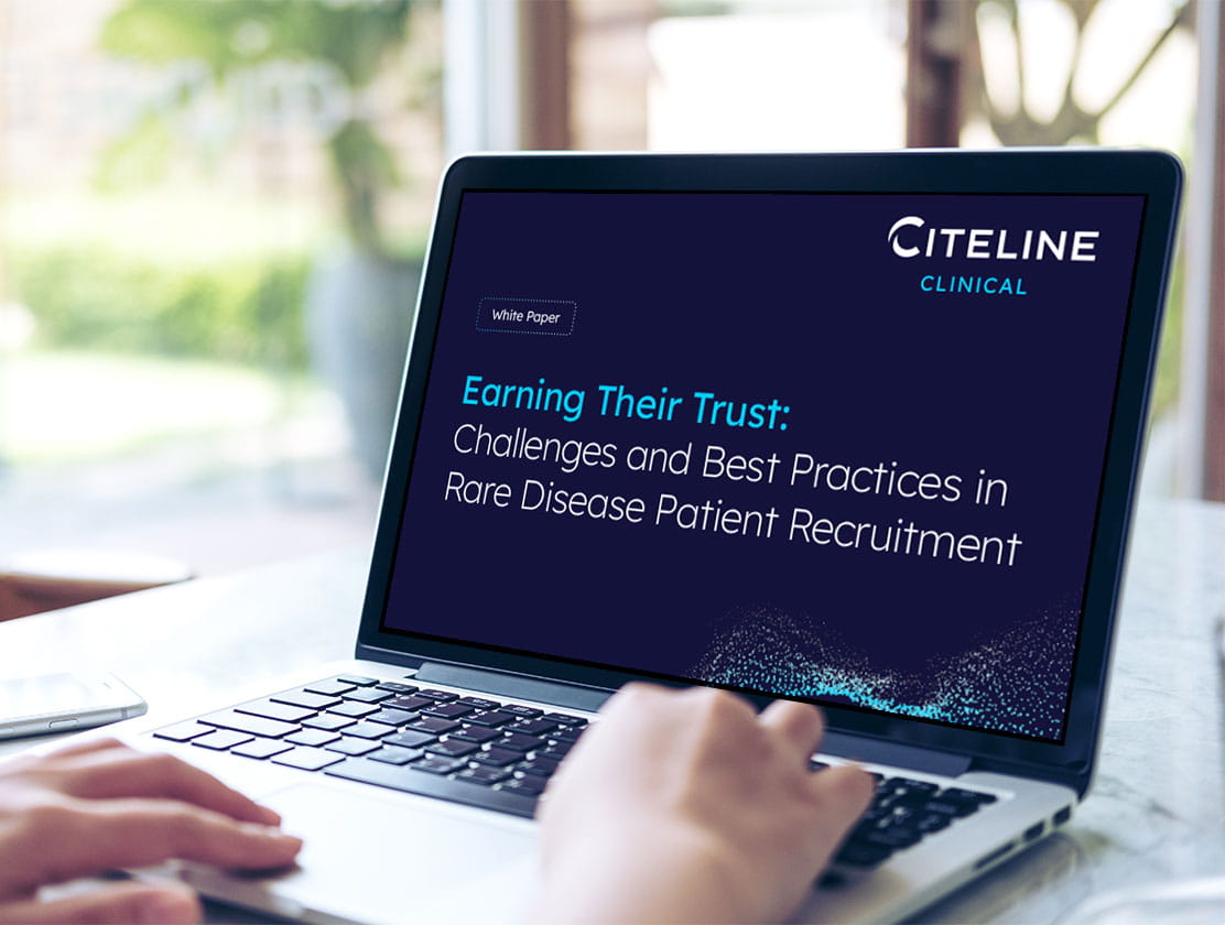 Person using a laptop to access the Earning Your Trust white paper PDF.