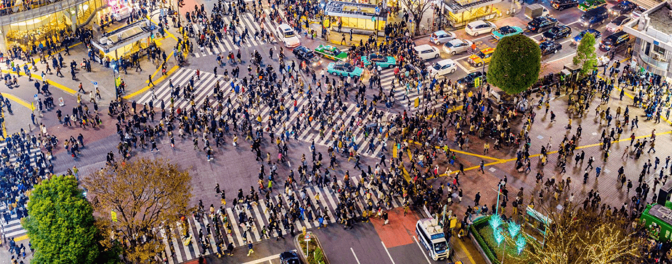 Aerial shot of a busy city intersection with cars and people.