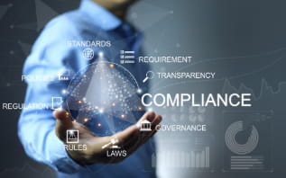 Concept illustration of compliance with a person holding a digital sphere containing terms like compliance, policies, regulation, laws, governance, requirement, transparency, and rules.