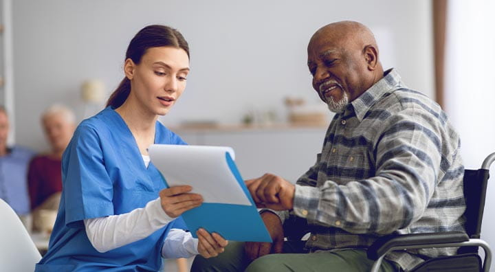 Healthcare professional and patient looking at patient chart together.