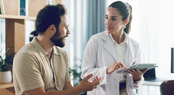 A healthcare professional discusses with a patient clinical trial summary results.
