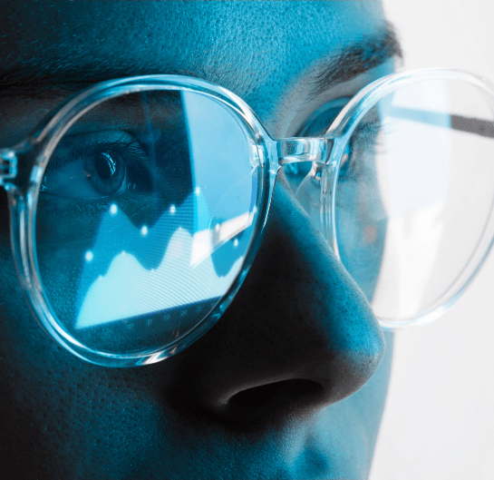 A person wearing glasses, looking at a graph displayed on the screen.